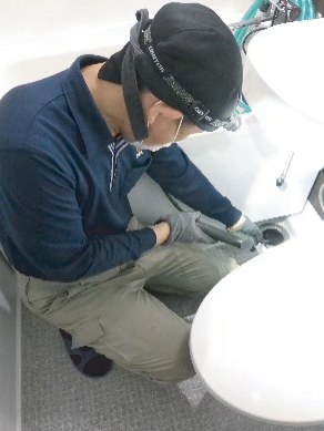 排水口の作業をするスタッフ