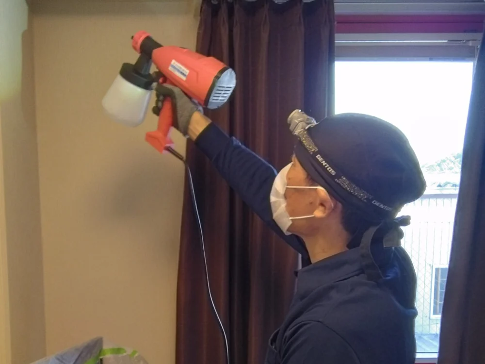 スプレーガンで消臭剤を噴霧する作業